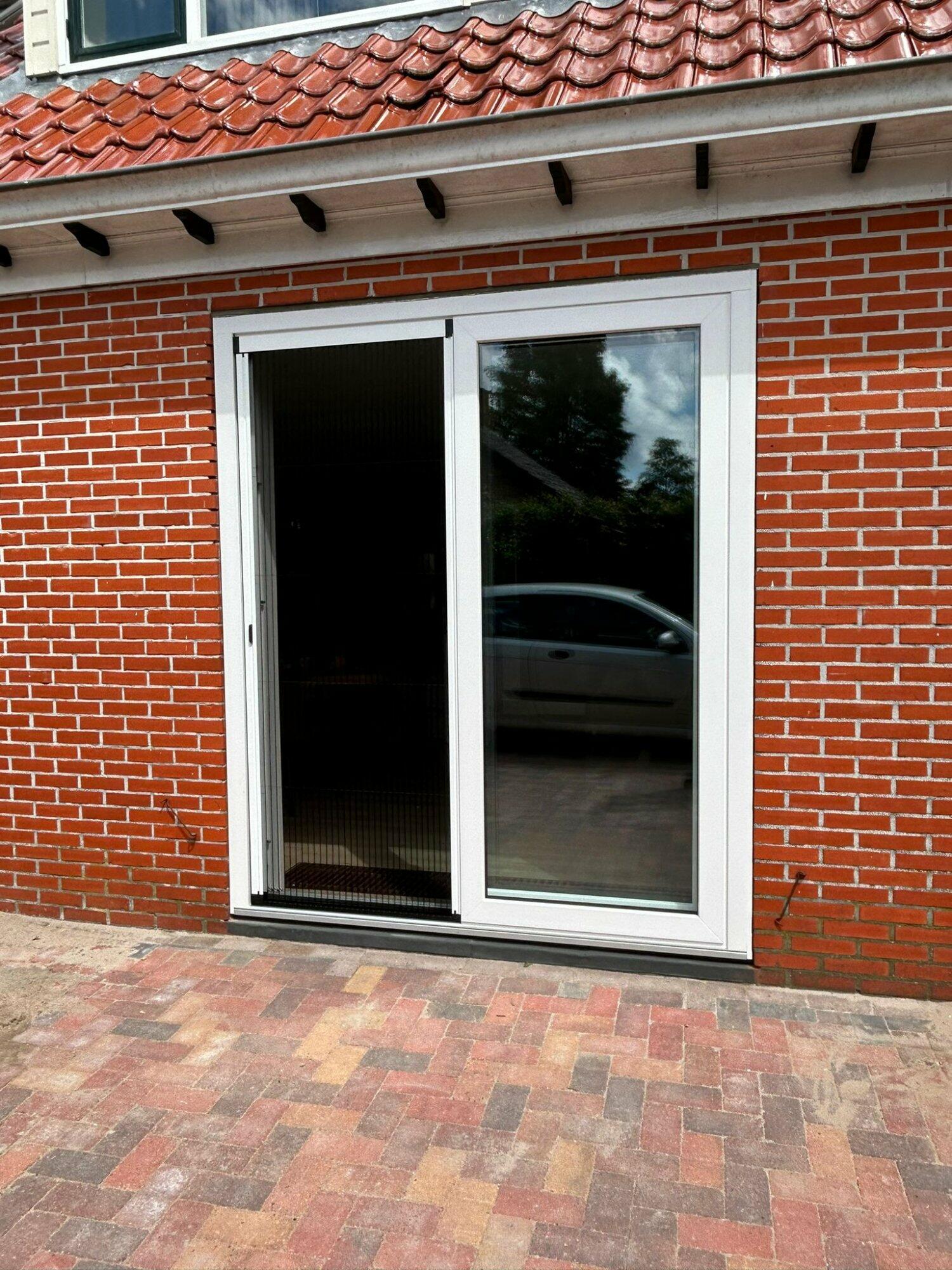 a door with glass in front of a brick building